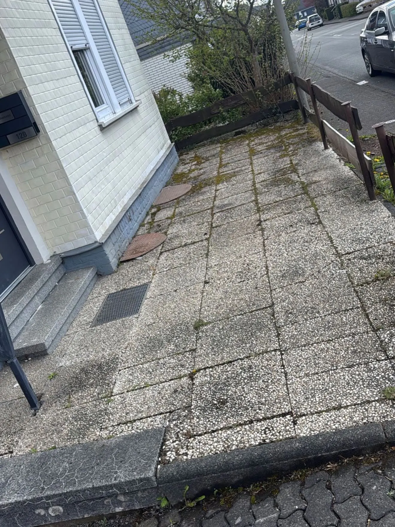 Ältere Waschbetonplatten entlang der Hauswand vor der Neugestaltung