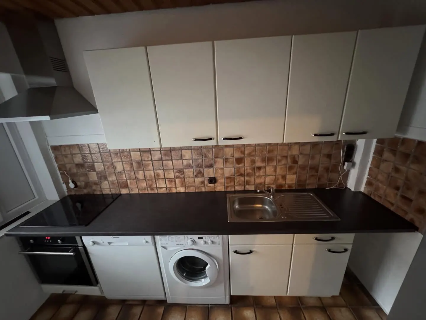 Helle Einbauküche vor der Aufwertung mit dunkler Arbeitsplatte und Mosaik-Fliesenspiegel